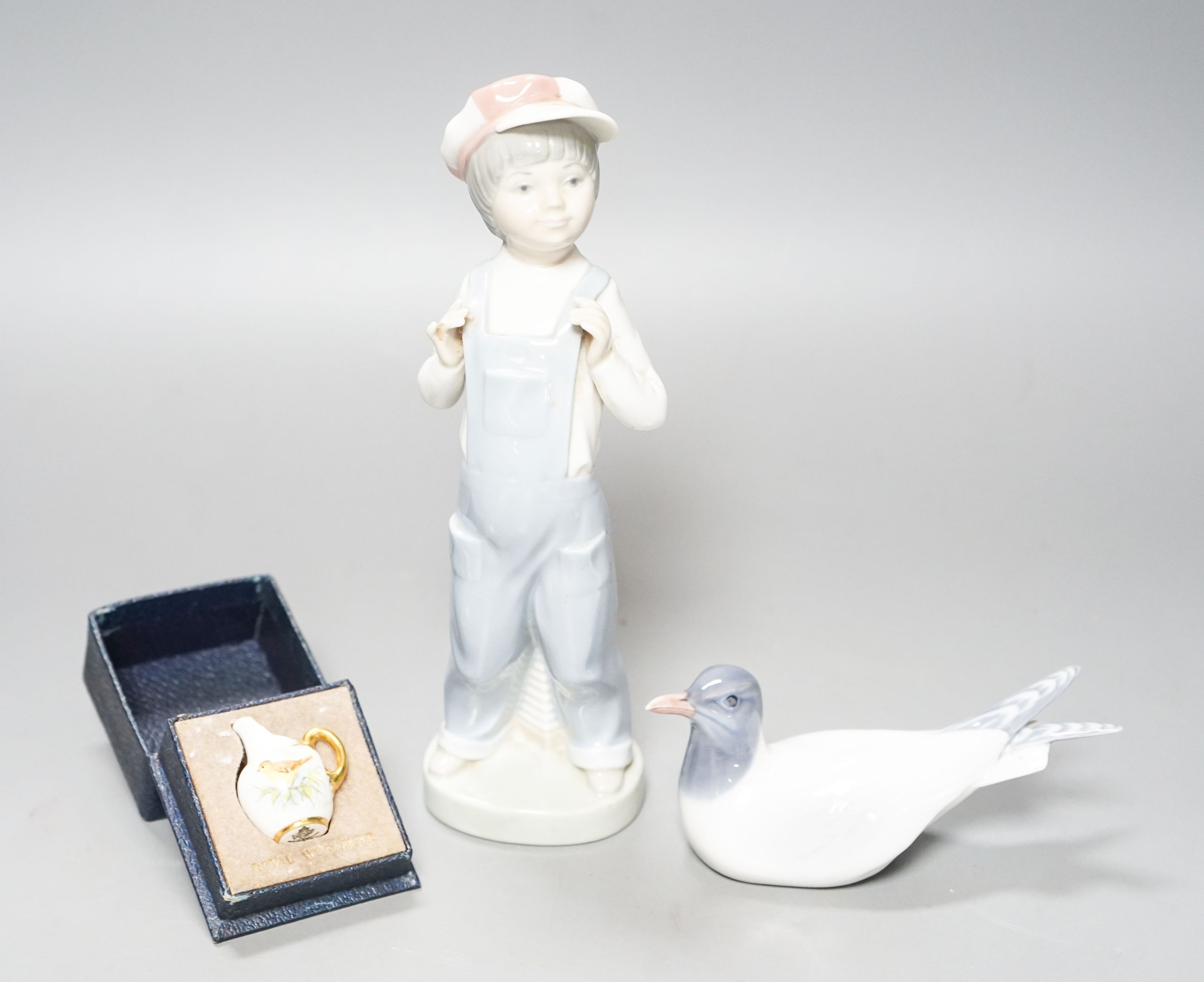 A Lladro figure of a young boy, 21.5cm high, a Royal Copenhagen model a tern, a cased miniature Royal Worcester jug, signed Norway?